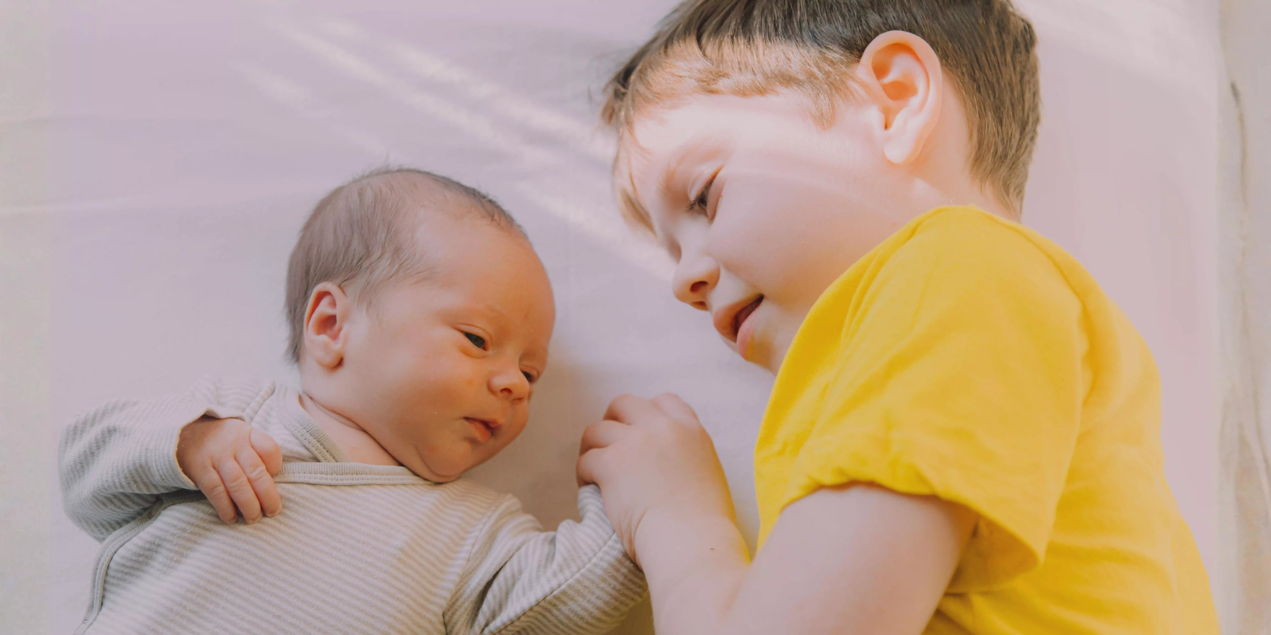 Hermano mayor junto a guagua recién nacida, cuidados para evitar contagios en casa